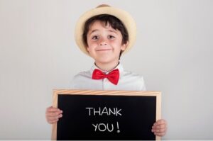 Child holding chalkboard that says "thank you"