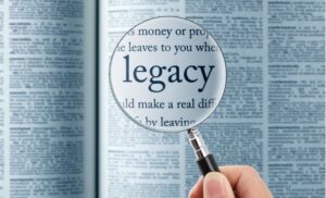 magnifying glass reading the word "legacy" in a dictionary